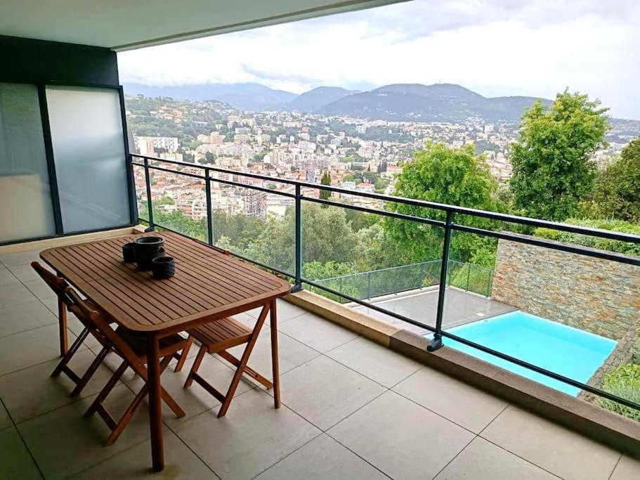 un balcon avec une table et une vue sur une ville dans l'établissement Péssicart - T2 avec terrasse - Résidence avec piscine, à Nice