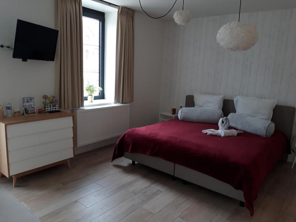 um quarto com uma cama com um urso de peluche em De Lokroep em Heers
