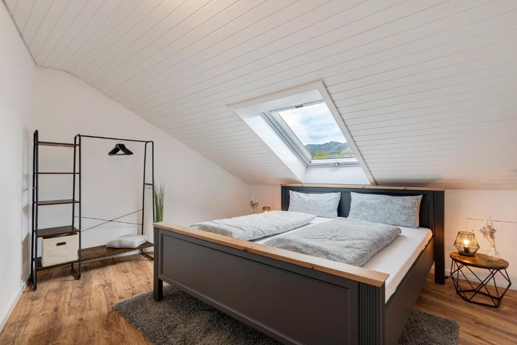 Schlafzimmer mit einem großen Bett und einem Dachfenster in der Unterkunft Dasensteinblick in Kappelrodeck