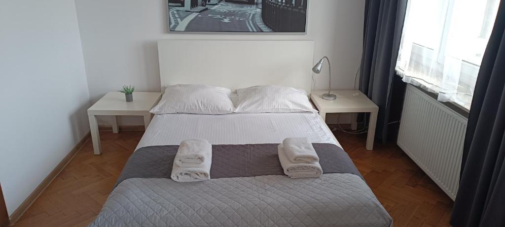 a small bedroom with a bed and two tables at Sleepy3city Władysława IV 50 in Gdynia