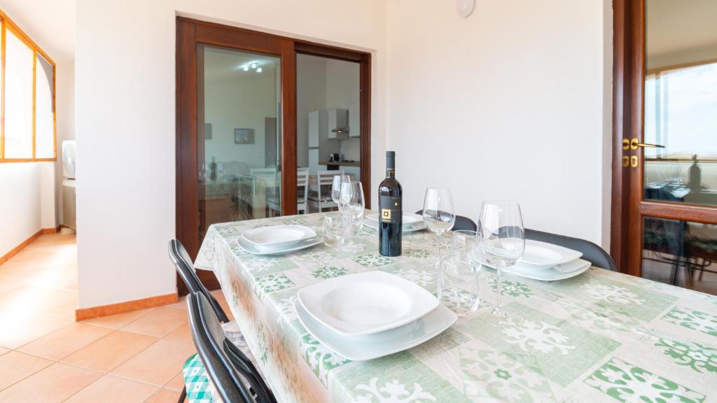 カブラスにあるSardinianworld - Zenzerino Apartment-Cabrasのダイニングテーブル(ワイン1本、グラス付)