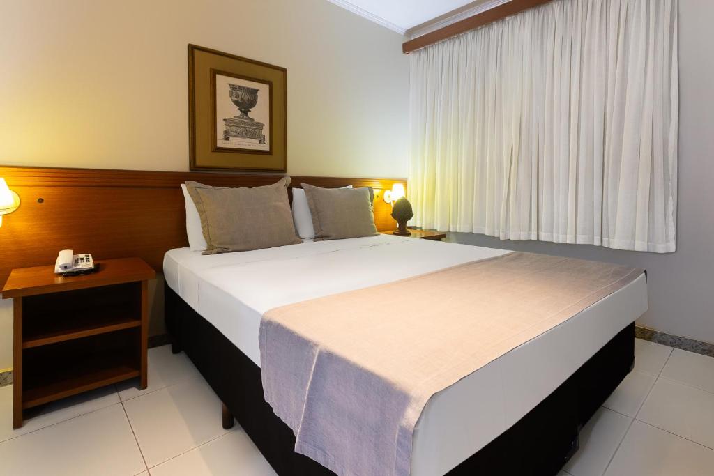Un dormitorio con una cama grande y una ventana en Hotel Dan Inn Ribeirão Preto, en Ribeirão Preto