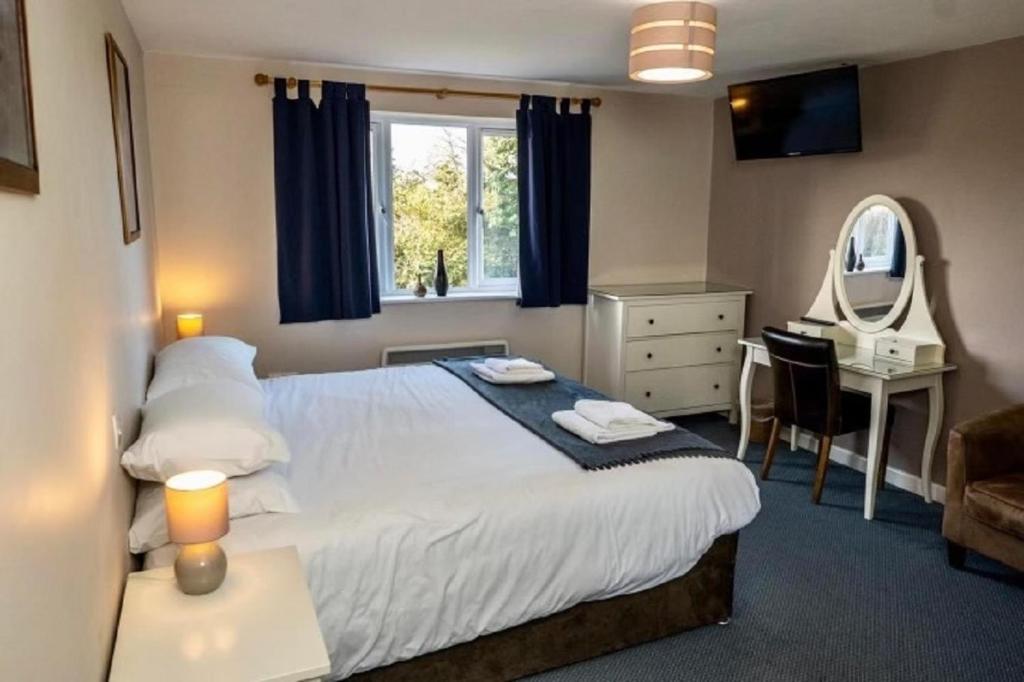 布里奇沃特的住宿－The Malt Shovel Inn，一间卧室配有一张床、一张书桌和一面镜子
