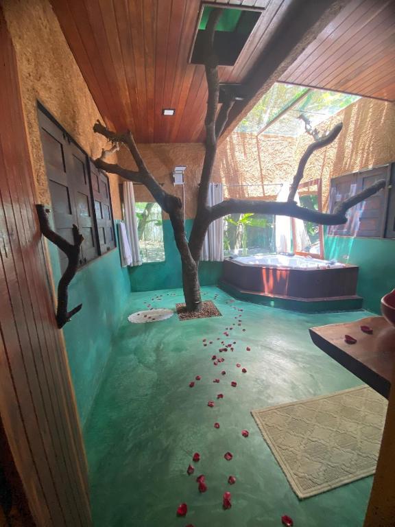 une chambre avec un faux arbre au sol dans l'établissement Chalé Céu estrelado, à Caruaru