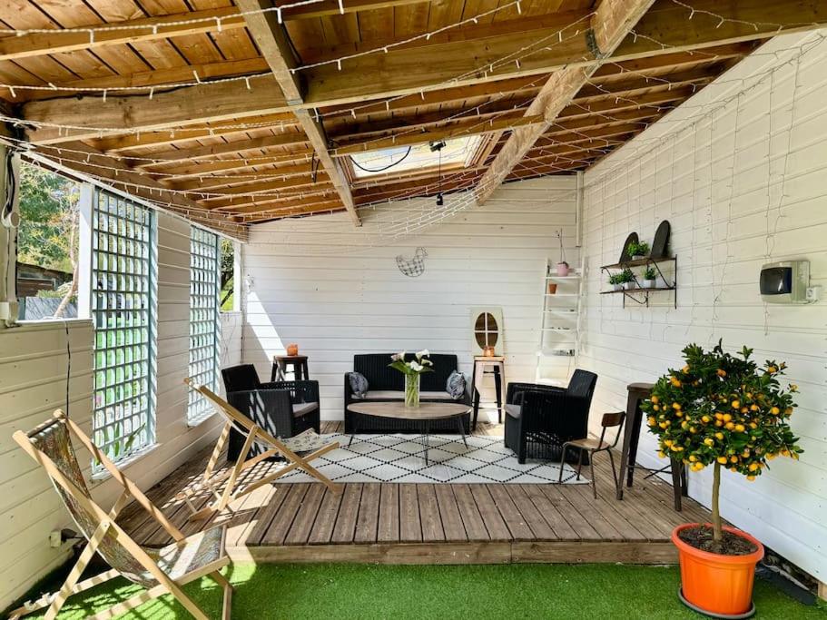 une véranda avec une table et des chaises dans l'établissement Le Muguet, maison de caractère à Bénodet, à Bénodet