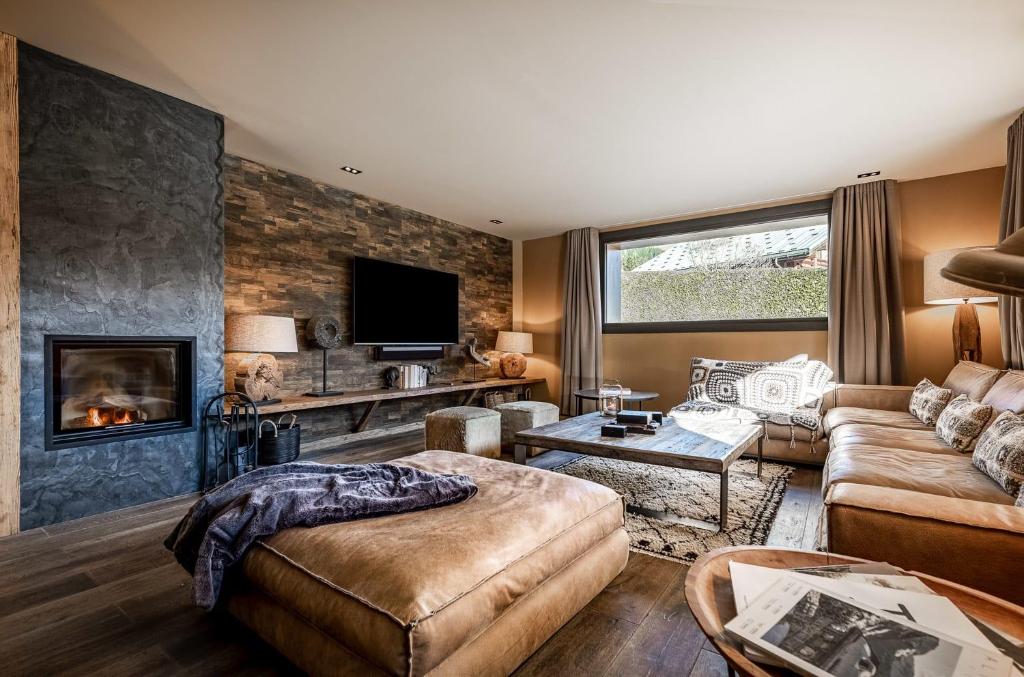 a living room with a couch and a fireplace at Chalet Virolo in Megève