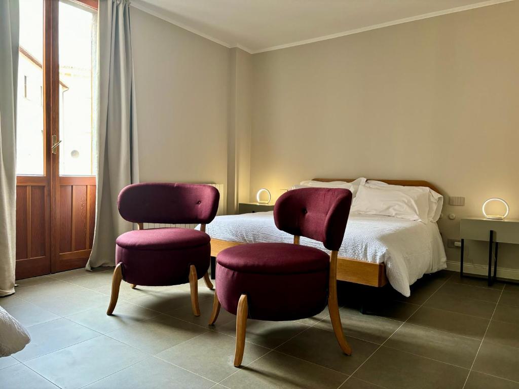 1 dormitorio con 2 sillas y 1 cama en Camere di Bianca, en Foligno