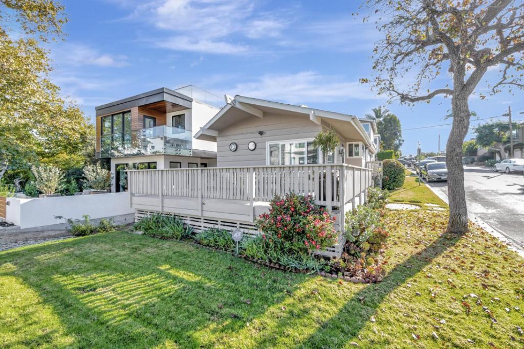 uma casa com uma cerca branca em frente a um quintal em Heart of Corona Del Mar 10 minute walk to beach steps to downtown em Newport Beach