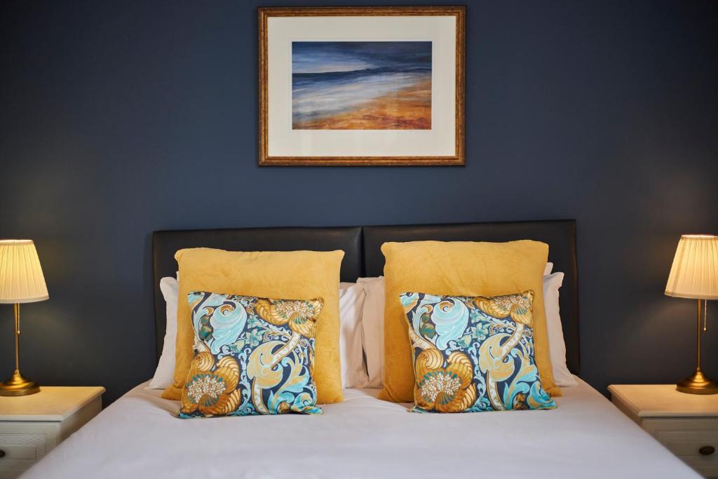 łóżko z dwoma poduszkami i zdjęciem na ścianie w obiekcie Cosy and convenient cottage w mieście Bishop Auckland