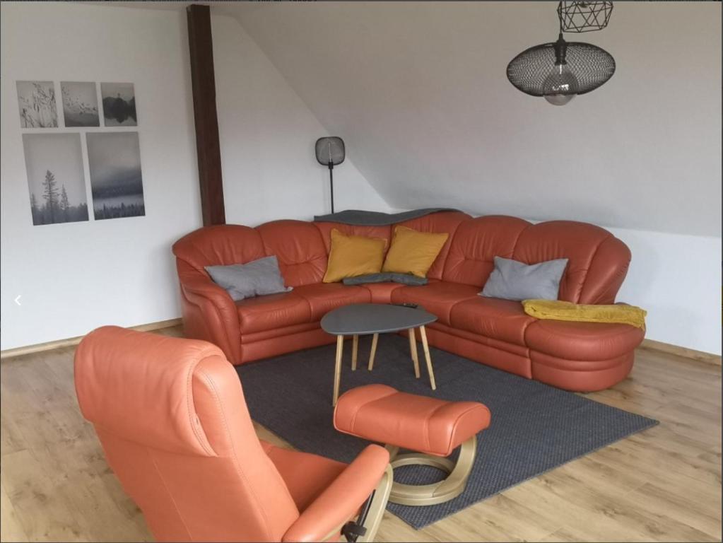 a living room with a leather couch and chairs at Ferienwohnung Familie Ossenbühl in Todendorf