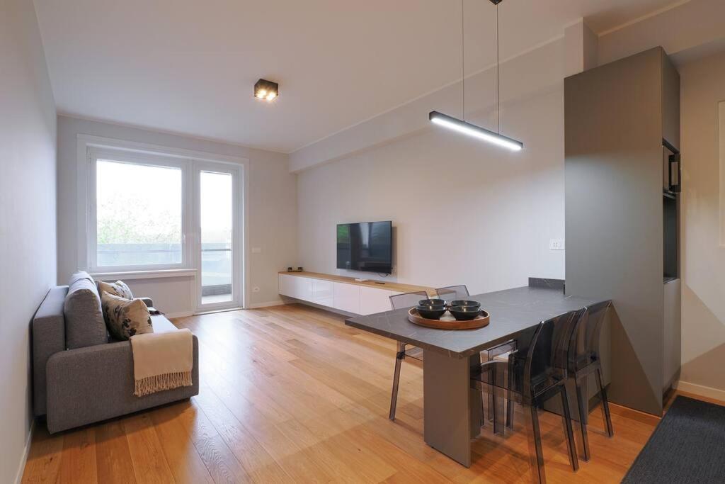 een woonkamer met een tafel, een bank en een televisie bij Contempora Apartments - Elvezia 8 - E43 in Milaan