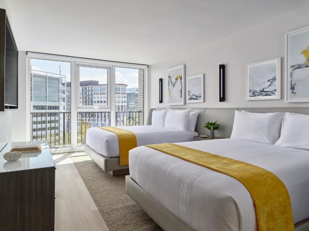 um quarto de hotel com duas camas e uma grande janela em Hotel AKA Washington Circle em Washington