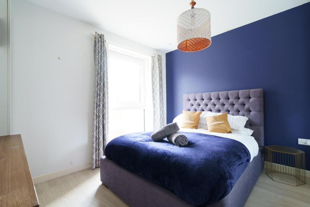 Dormitorio con cama morada y pared azul en Nyland House, en Londres