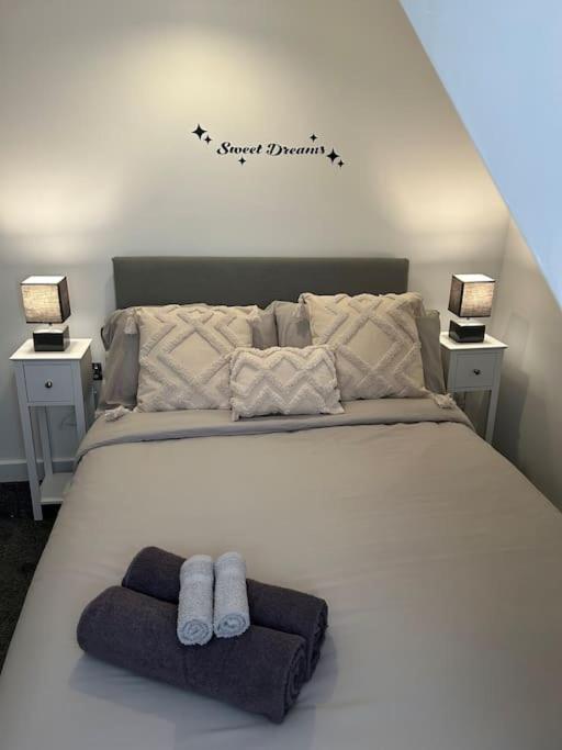 a bedroom with a bed with two towels on it at Rock Park Penthouse in Llandrindod Wells