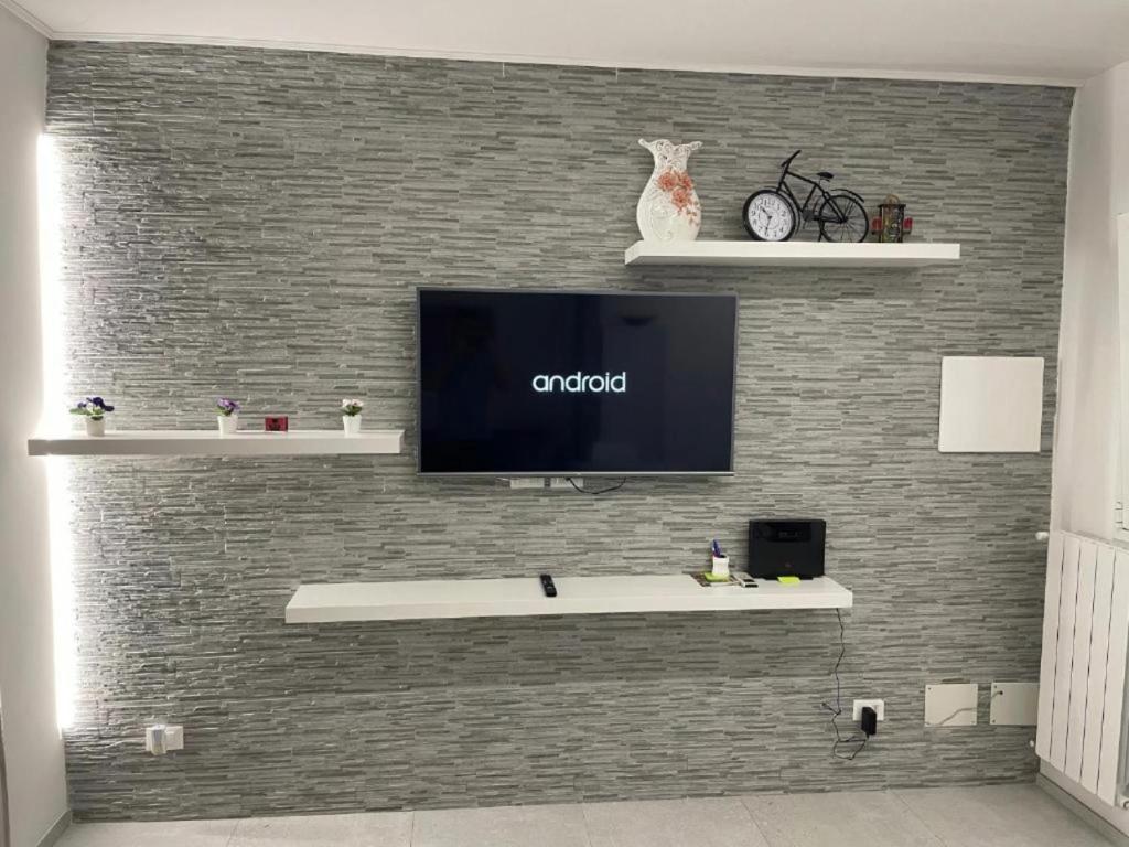 una parete con TV a schermo piatto su un muro di mattoni di Casa Emilia a Ragusa