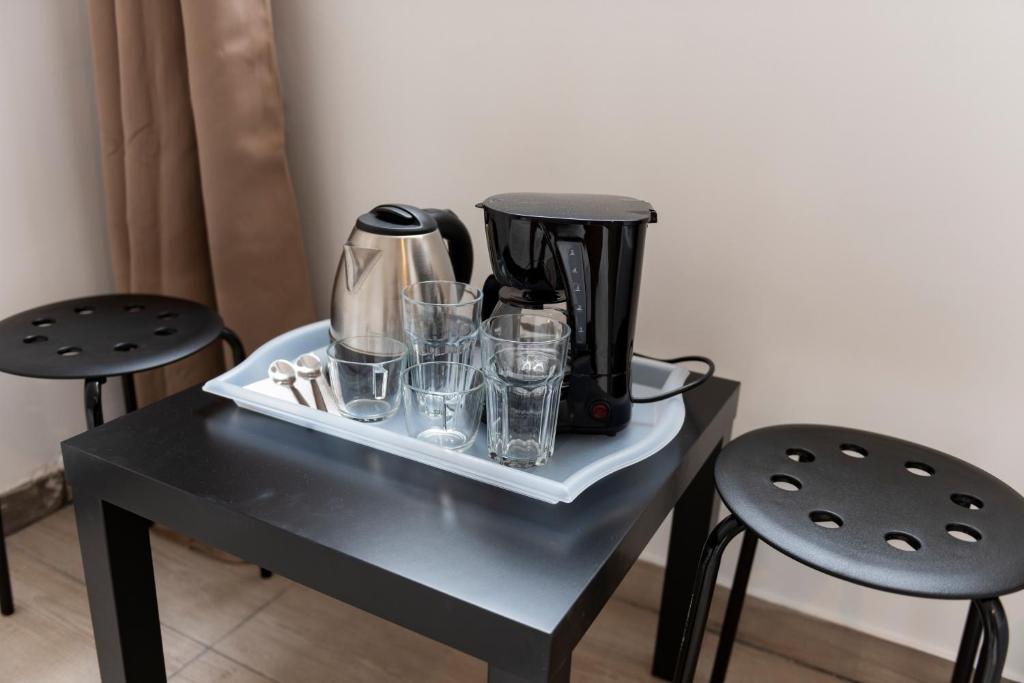 een zwart koffiezetapparaat op een tafel met glazen bij Liberal Metaxourgeio in Athene