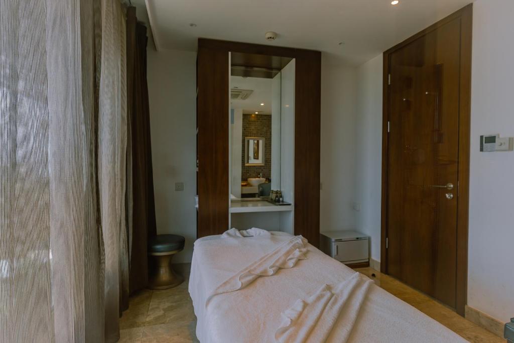 a bedroom with a bed and a bathroom with a mirror at Crowne Plaza Nairobi Airport by IHG in Nairobi