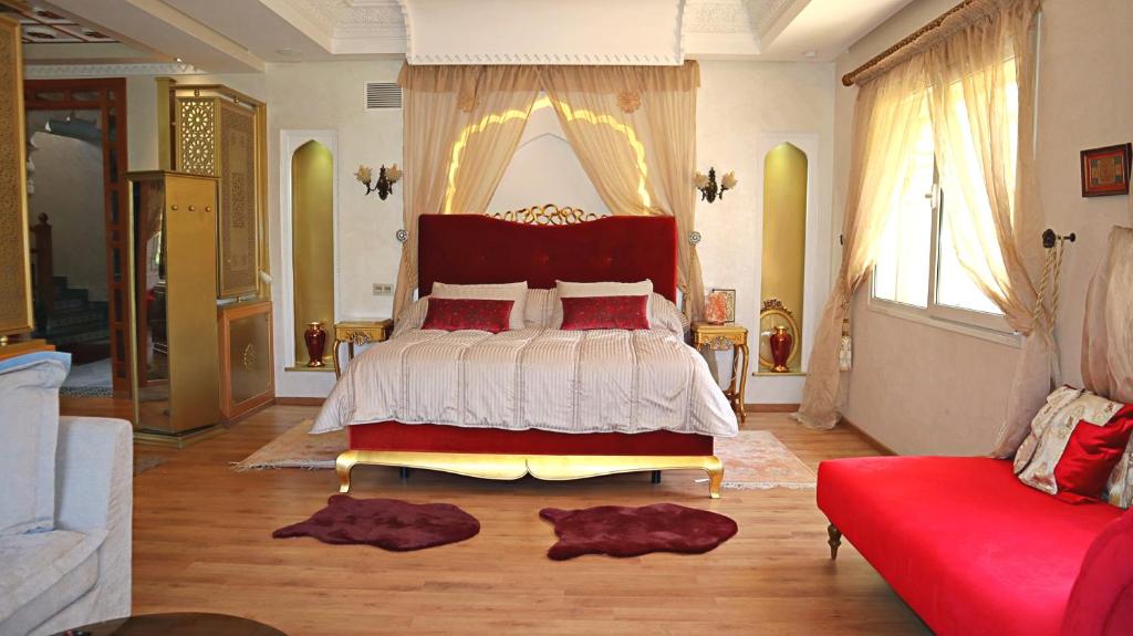 - une chambre avec un lit et un canapé rouge dans l'établissement Barthélemy Guest House, à Marrakech