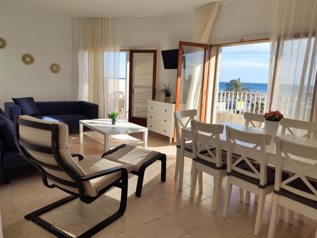 a living room with a table and chairs and a view of the ocean at Sol y Mar Segur in Segur de Calafell