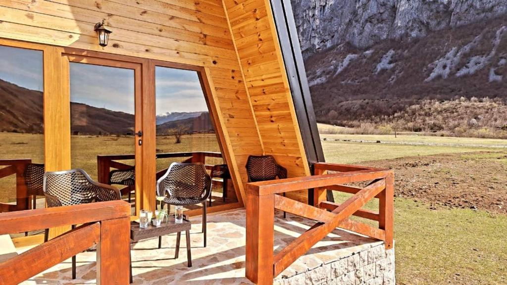 eine Holzhütte mit einem Tisch und Stühlen auf einer Veranda in der Unterkunft Silence House in Šavnik