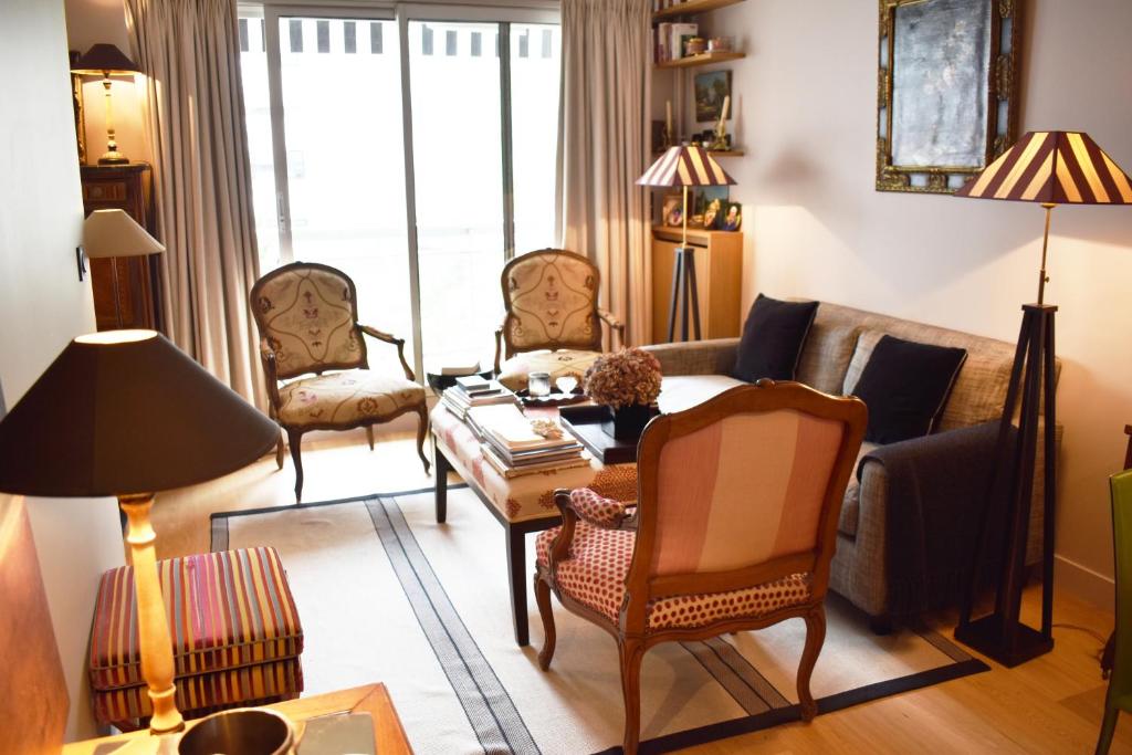 uma sala de estar com um sofá e cadeiras em La Défense - Paris em Neuilly-sur-Seine