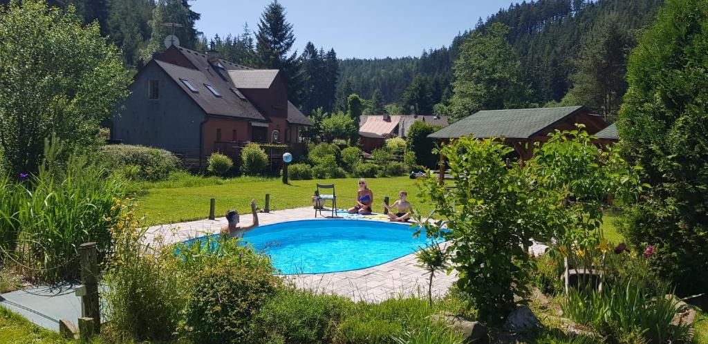 un groupe de personnes assises autour d'une piscine dans l'établissement Podskalí Adršpach, à Teplice
