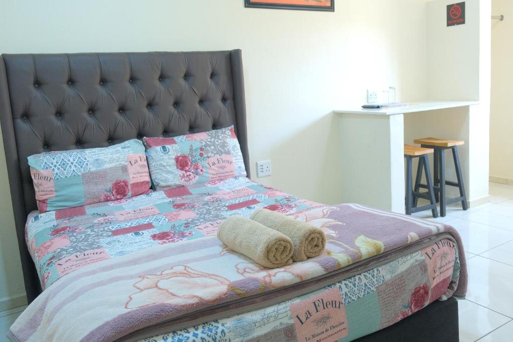 1 dormitorio con 1 cama con sábanas y toallas de regalo en SUPA LODGE, en Parow