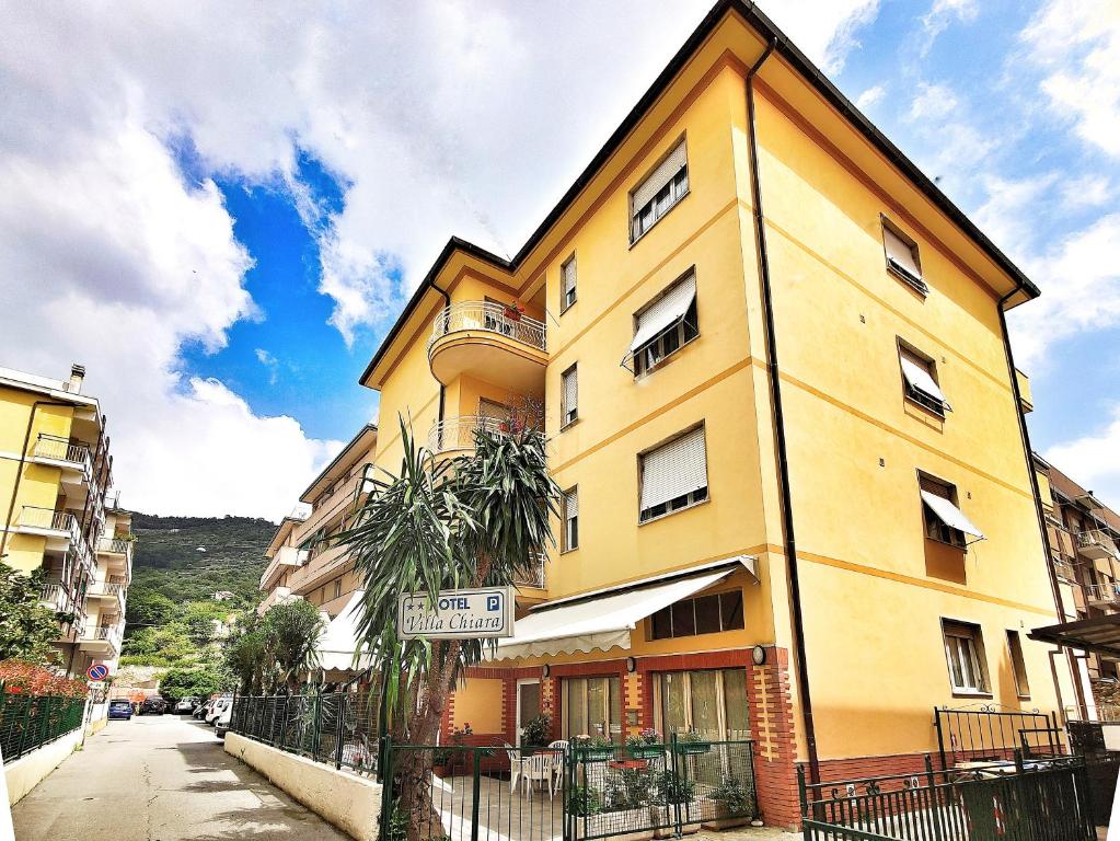 a yellow building on the side of a street at Hotel Villa Chiara in Finale Ligure