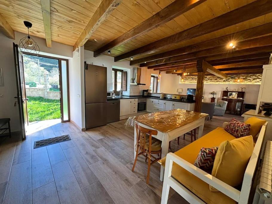 a living room with a table and a kitchen at La Casa de la Abuela Concha in Felmín