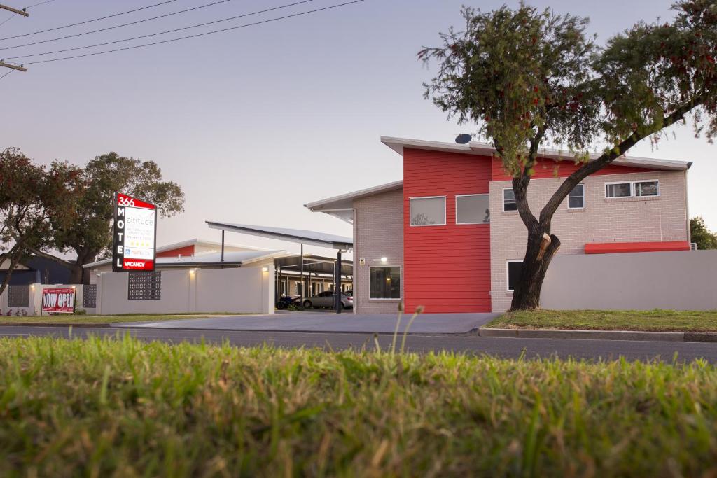 ein Gebäude mit einer roten Tür auf einer Straße in der Unterkunft Altitude Motel Apartments in Toowoomba