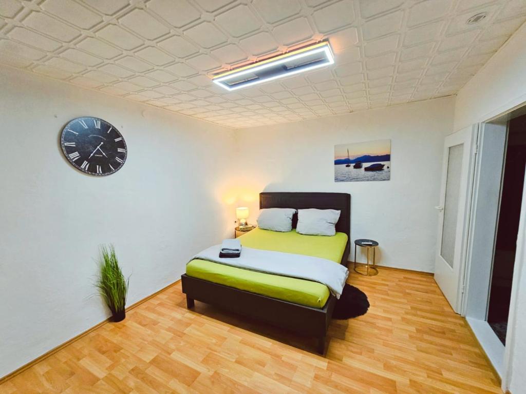 ein Schlafzimmer mit einem Bett und einer Uhr an der Wand in der Unterkunft B&R Ferienhaus In der Nähe des Flughafens in Nürnberg