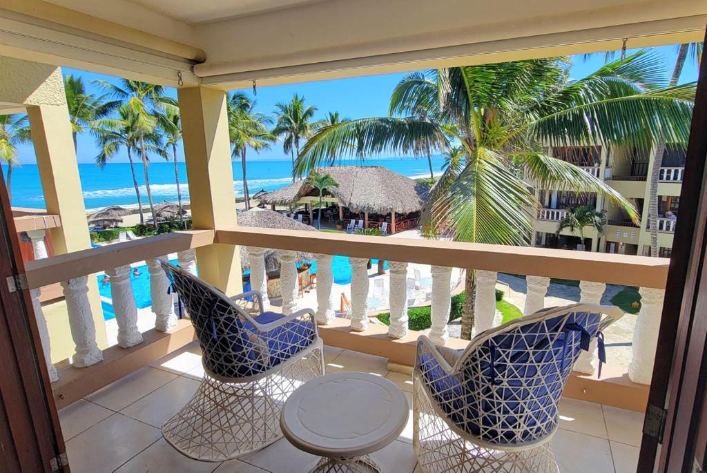 a balcony with chairs and a table and the ocean at Oceanview Penthouse on the Beach in Cabarete