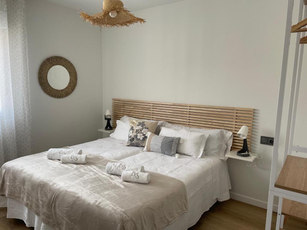 1 dormitorio con 1 cama blanca y 2 almohadas en BULEVAR SUITE, en Nava de la Asunción