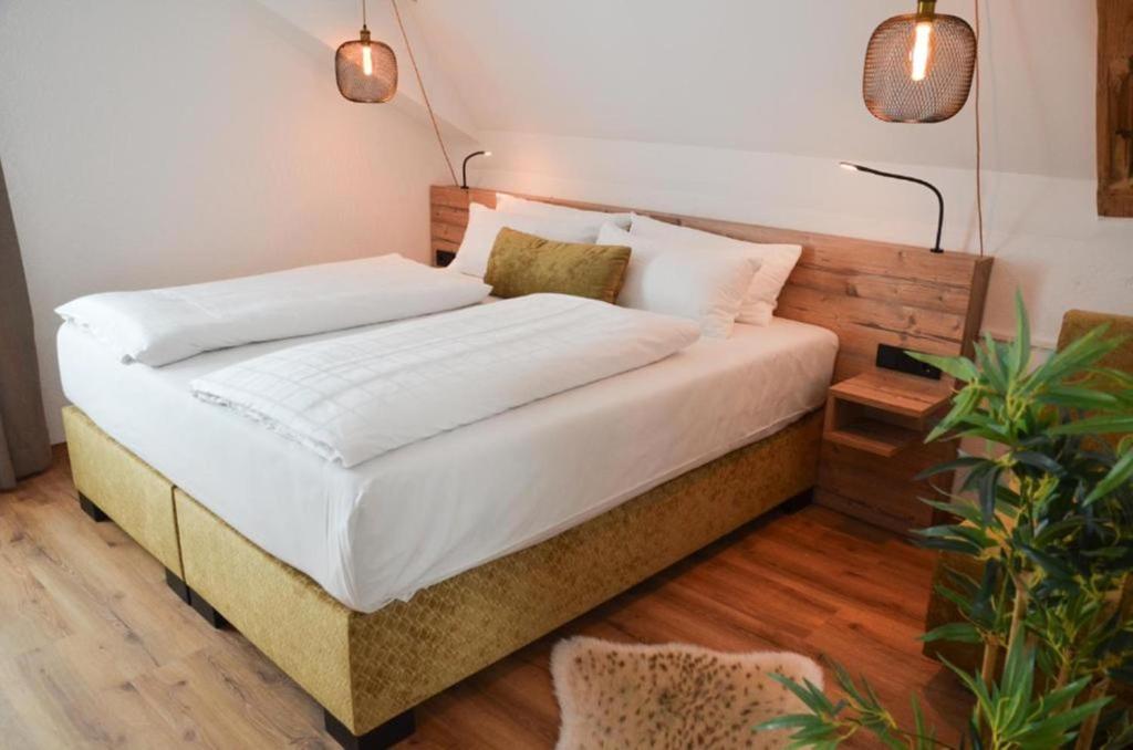 ein Bett mit weißer Bettwäsche und Kissen in einem Schlafzimmer in der Unterkunft Gasthof zum Ritter - a cozy historical Landmark in Ulm