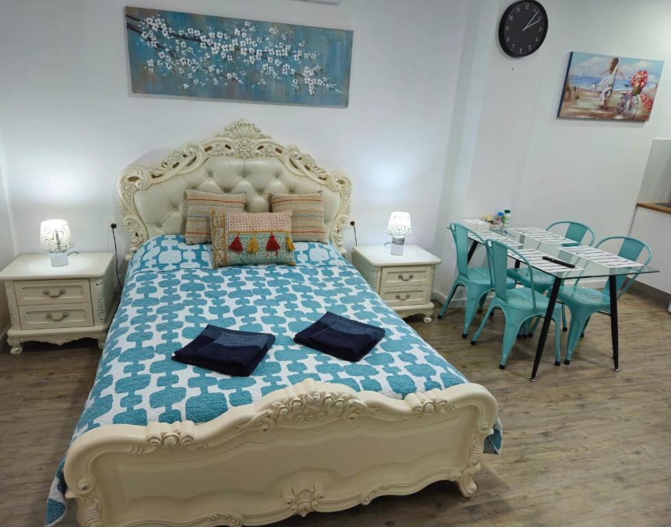 een slaapkamer met een bed en een tafel met stoelen bij APARTAMENTOS ELEMAR in Málaga