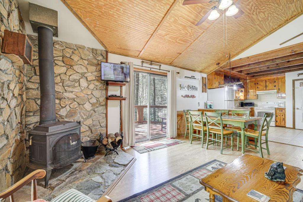 - un salon avec un poêle à bois et une table dans l'établissement Creekside Cabin with Deck by Hiking Trails and Fishing, à Whittier