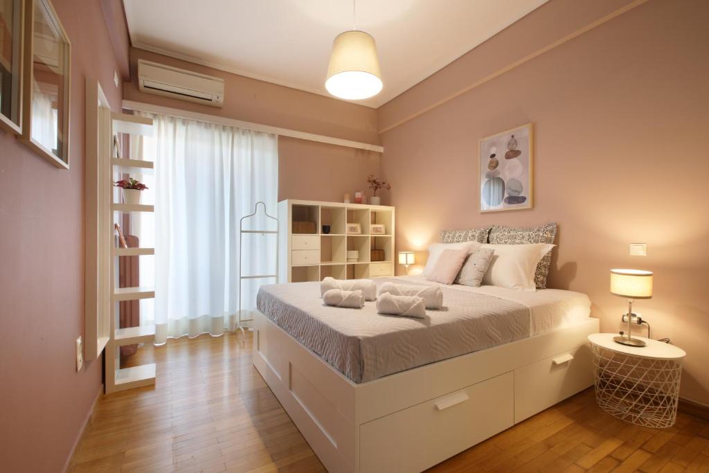 ein Schlafzimmer mit einem großen weißen Bett in einem Zimmer in der Unterkunft Modern 2BD apartment next to Acropolis in Athen