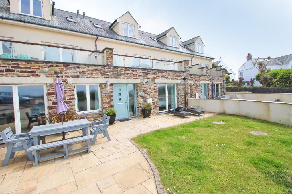 a brick building with a patio with a picnic table at BY THE BEACH, spacious apartment in St Merryn
