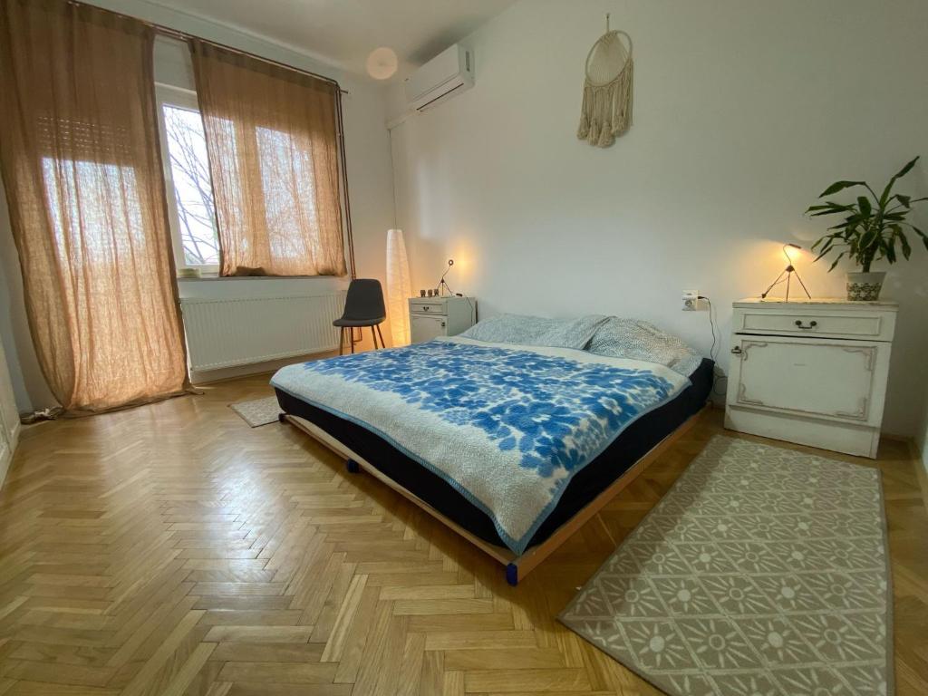 a bedroom with a bed and a rug on a wooden floor at Moon Tree *** in Varaždin