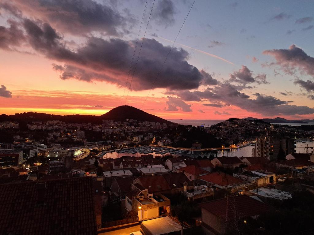 una puesta de sol sobre una ciudad con una montaña en el fondo en Villa Ivan, en Dubrovnik