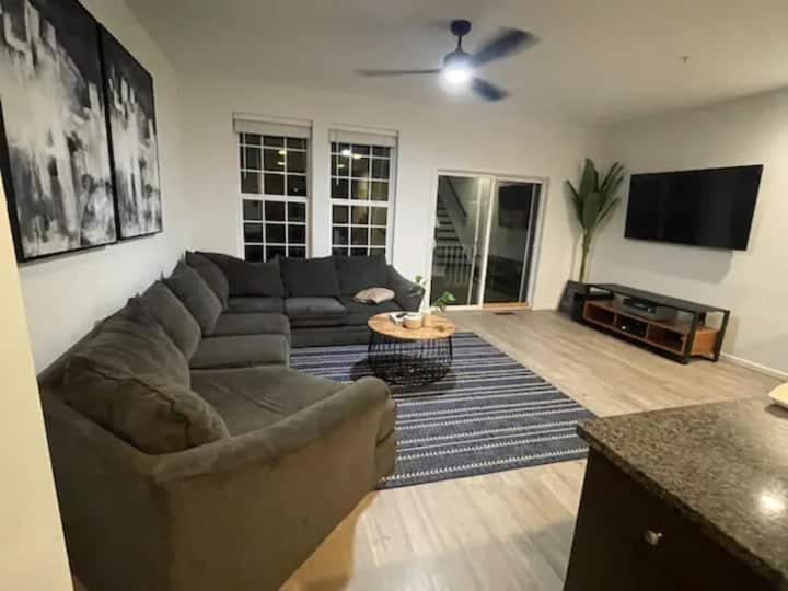 een woonkamer met een bank en een flatscreen-tv bij 3 beautiful Bedroom Townhome in Germantown