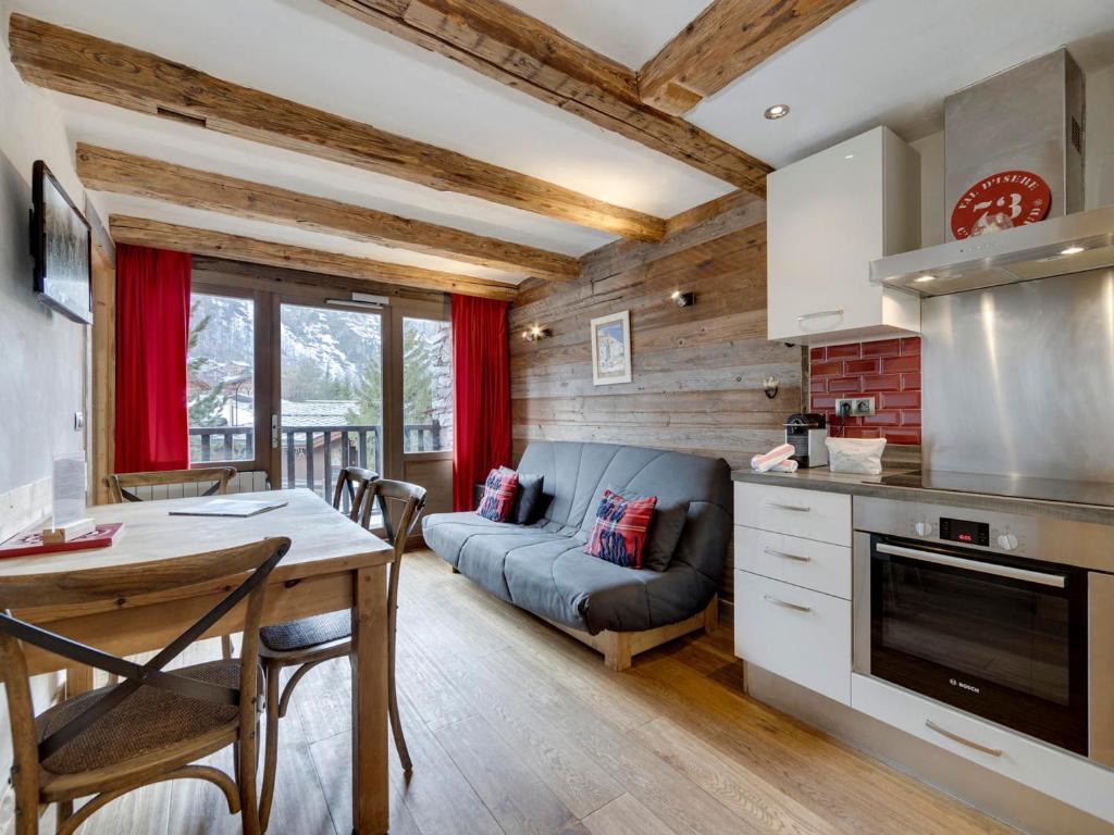 eine Küche und ein Wohnzimmer mit einem Tisch und einem Sofa in der Unterkunft Appartement Val-d'Isère, 3 pièces, 4 personnes - FR-1-567-65 in Val dʼIsère
