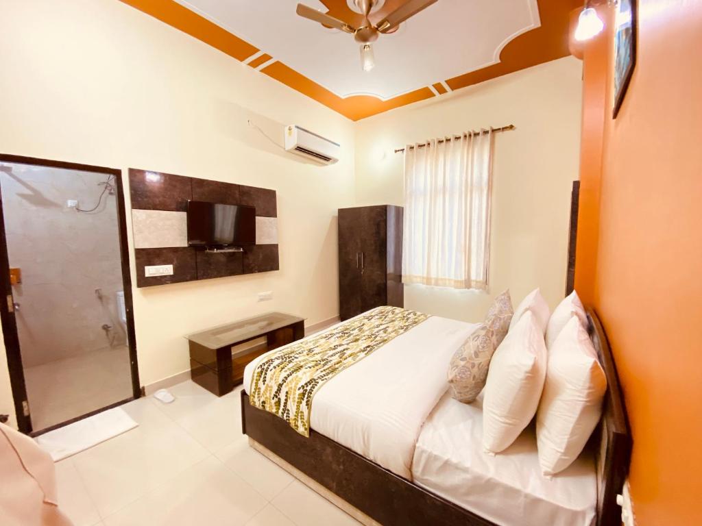 um quarto com uma cama e uma televisão em The Tiger Heritage em Sawai Madhopur