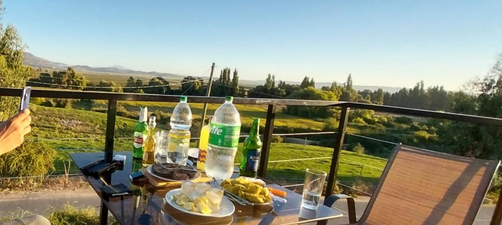 una mesa con comida y bebida en el balcón en Terraza vista hermosa, en Lolol