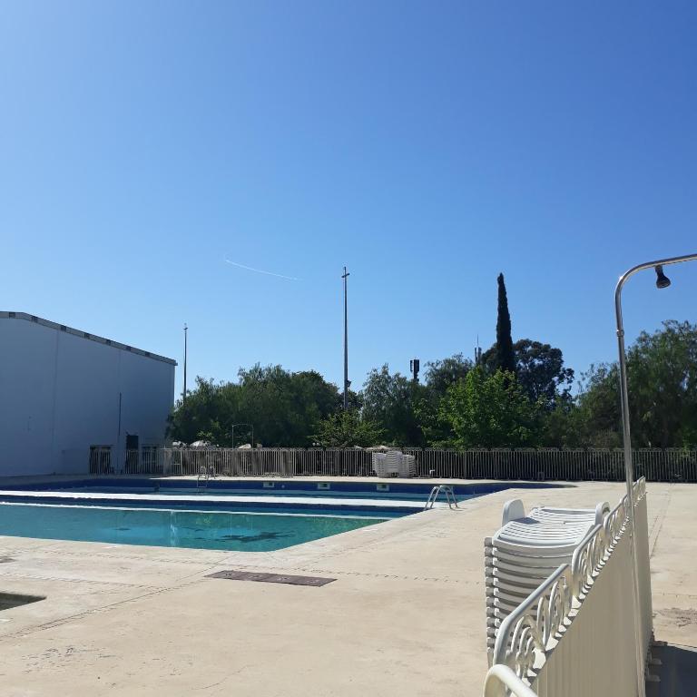 - une piscine avec des chaises et un éclairage de rue dans l'établissement RESIDENCE L'ILE D'OR, à La Londe-les-Maures