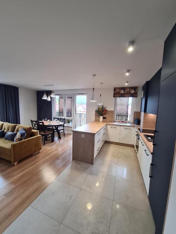 a kitchen and living room with a couch and a table at Apartament przy tężni in Augustów