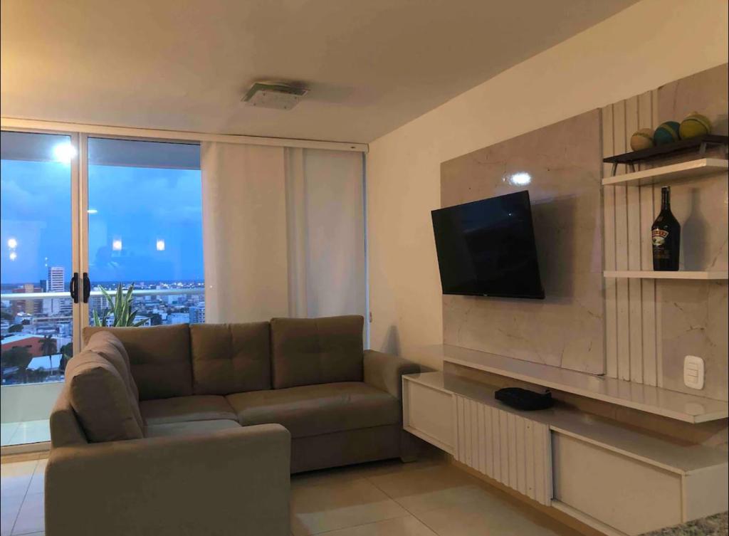 sala de estar con sofá y TV de pantalla plana en Norte Barranquilla amoblado, en Barranquilla