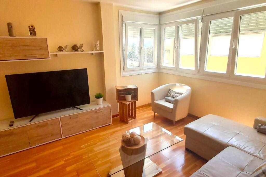a living room with a flat screen tv and a couch at Apartamento Playa Foz in Foz