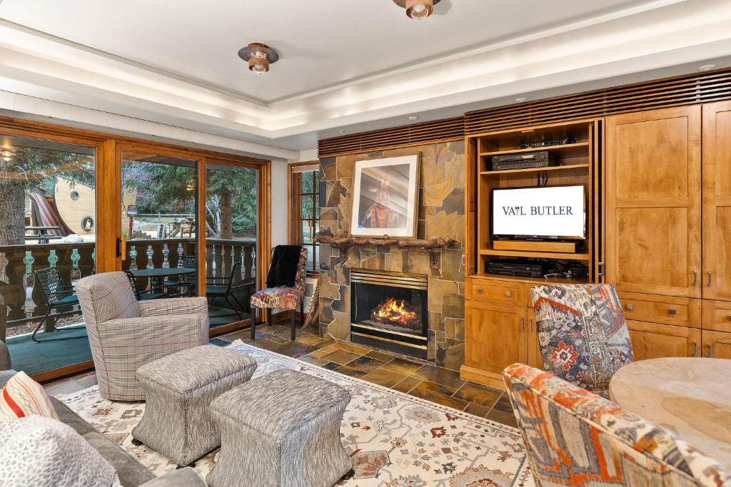 a living room with a fireplace and a television at Bridge Street - Unit 202 in Vail