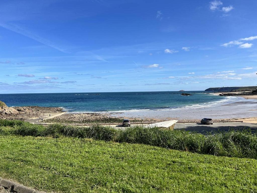 une vue d'une plage avec l'océan dans l'établissement 357 - Appartement T3 à 100m de l'Anse du Croc., à Fréhel